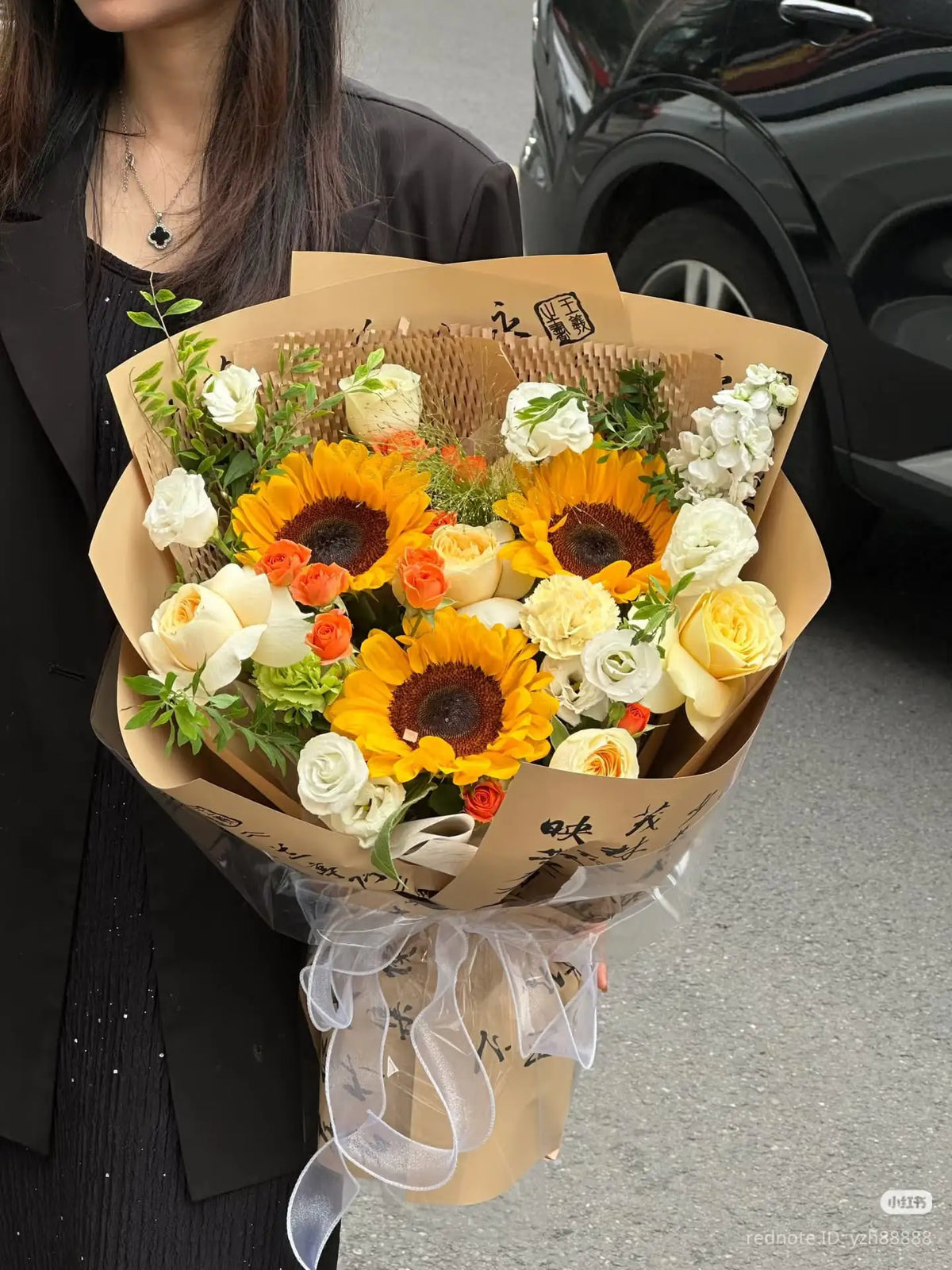 Woman holding rustic sunflower bouquet with white and yellowish flowers and greenery