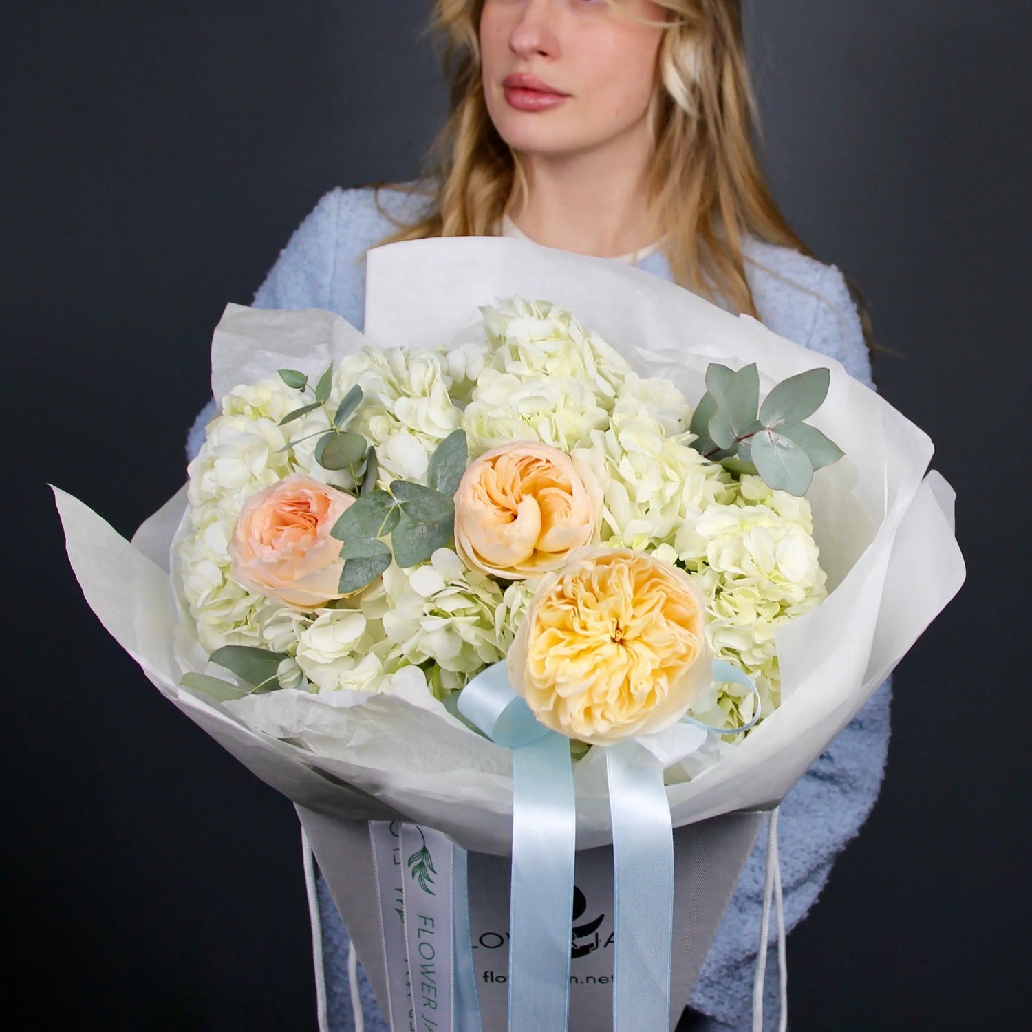 bouquet of flowers with a woman in a light blue dress