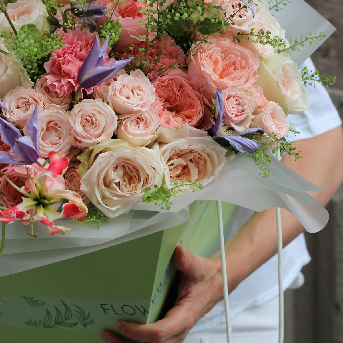 A close up on roses and gloriosa flowers inside a green transporttion box