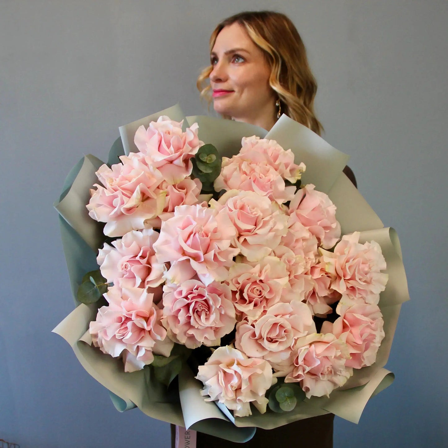 Woman holding a large bouquet of pink flowers roses with delvery in genova