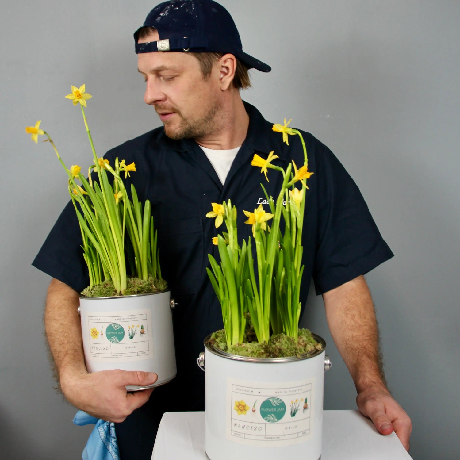 man holding two buckets of yellow narcissus