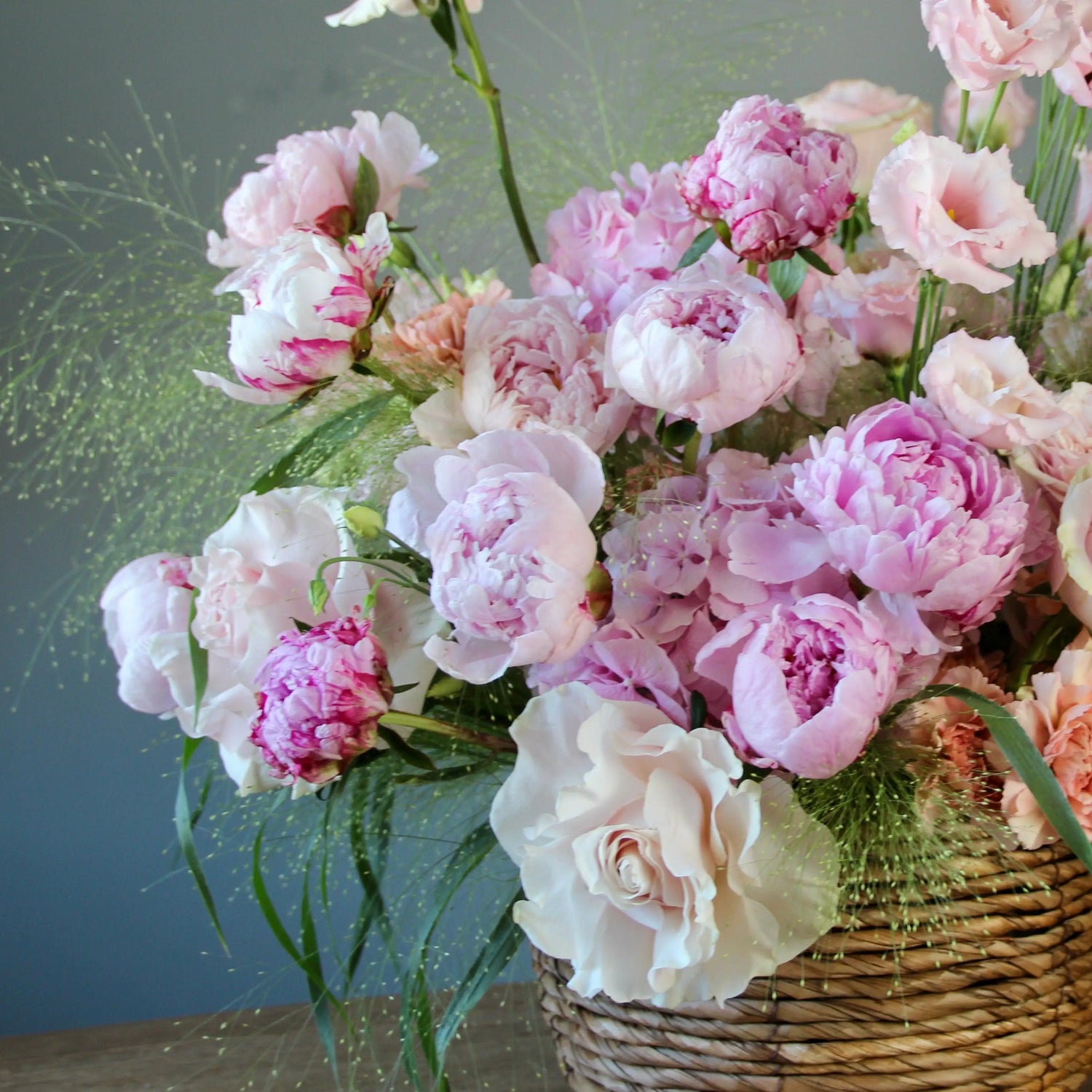 pink peonies with greenery in a basket