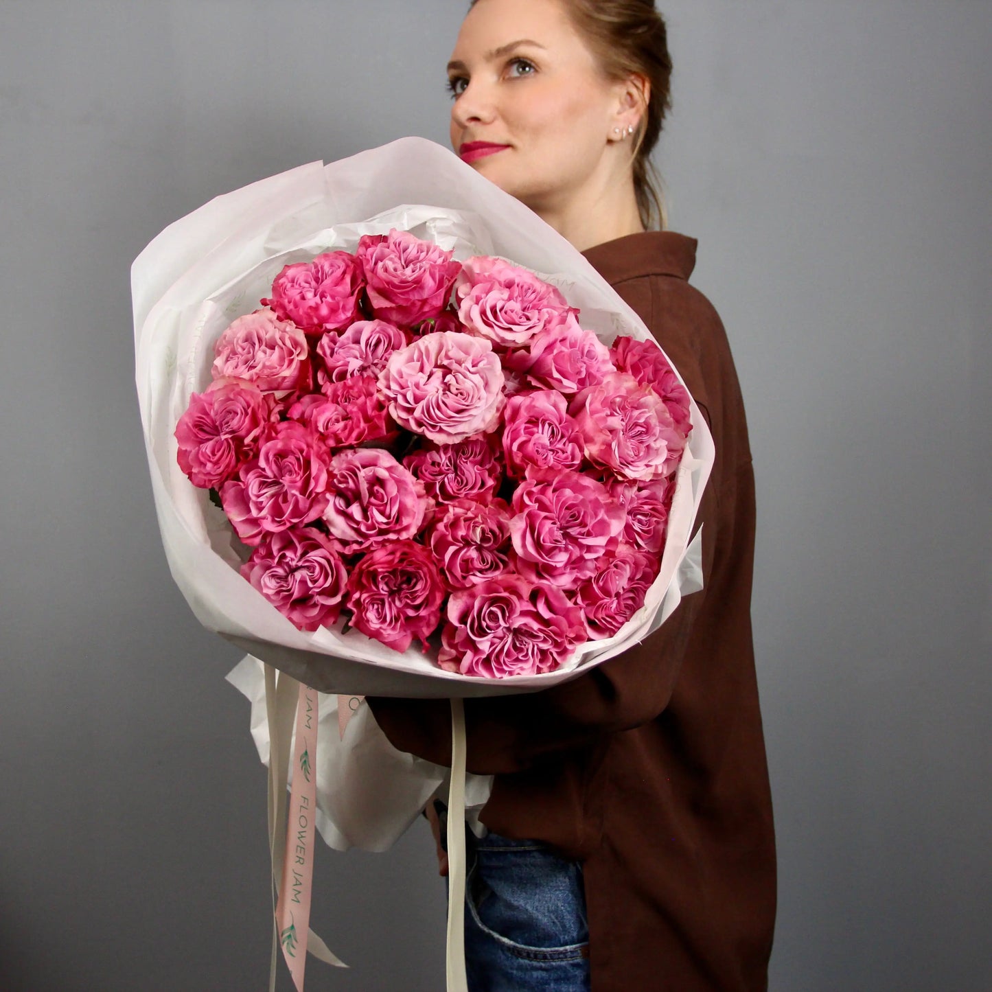 woman holding a big bouquet of pink roses